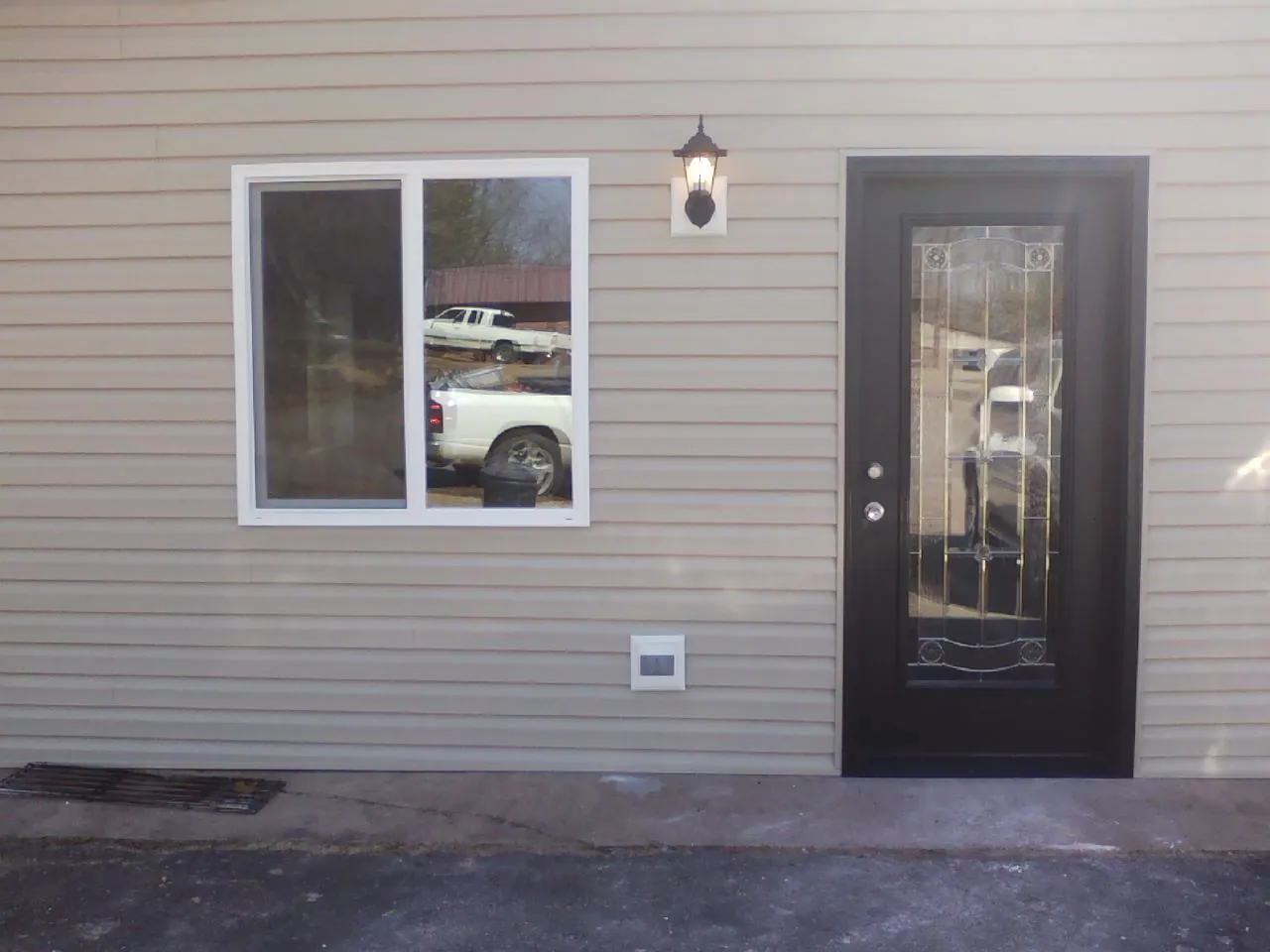 New siding, window and entry door on the side of an addition in East Wakefield