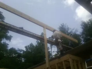 Carpenter setting a ridge beam over a new addition frame — Ice Dam Removal by Roofing Brothers in East Wakefield