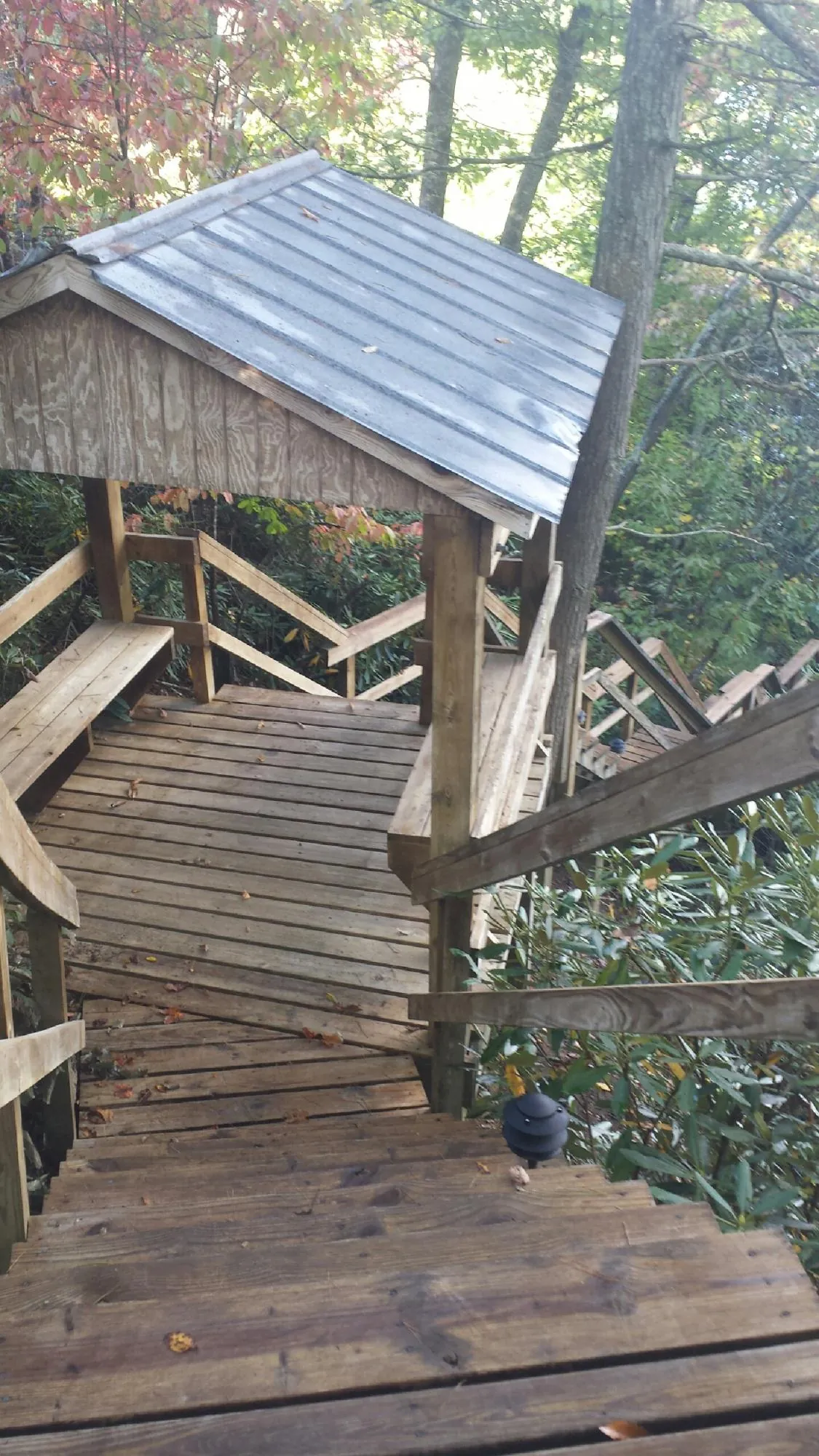 Metal roofed shelter over wooden steps on a wooded walkway — Skylight Repair & Installation work by our crew in East Wakefield