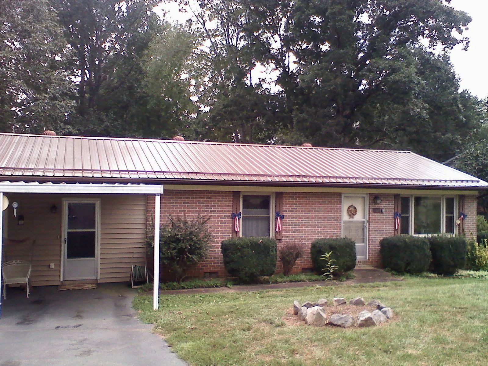 Bronze metal roof and carport on a brick ranch home — Roof Repair work by our crew in East Wakefield